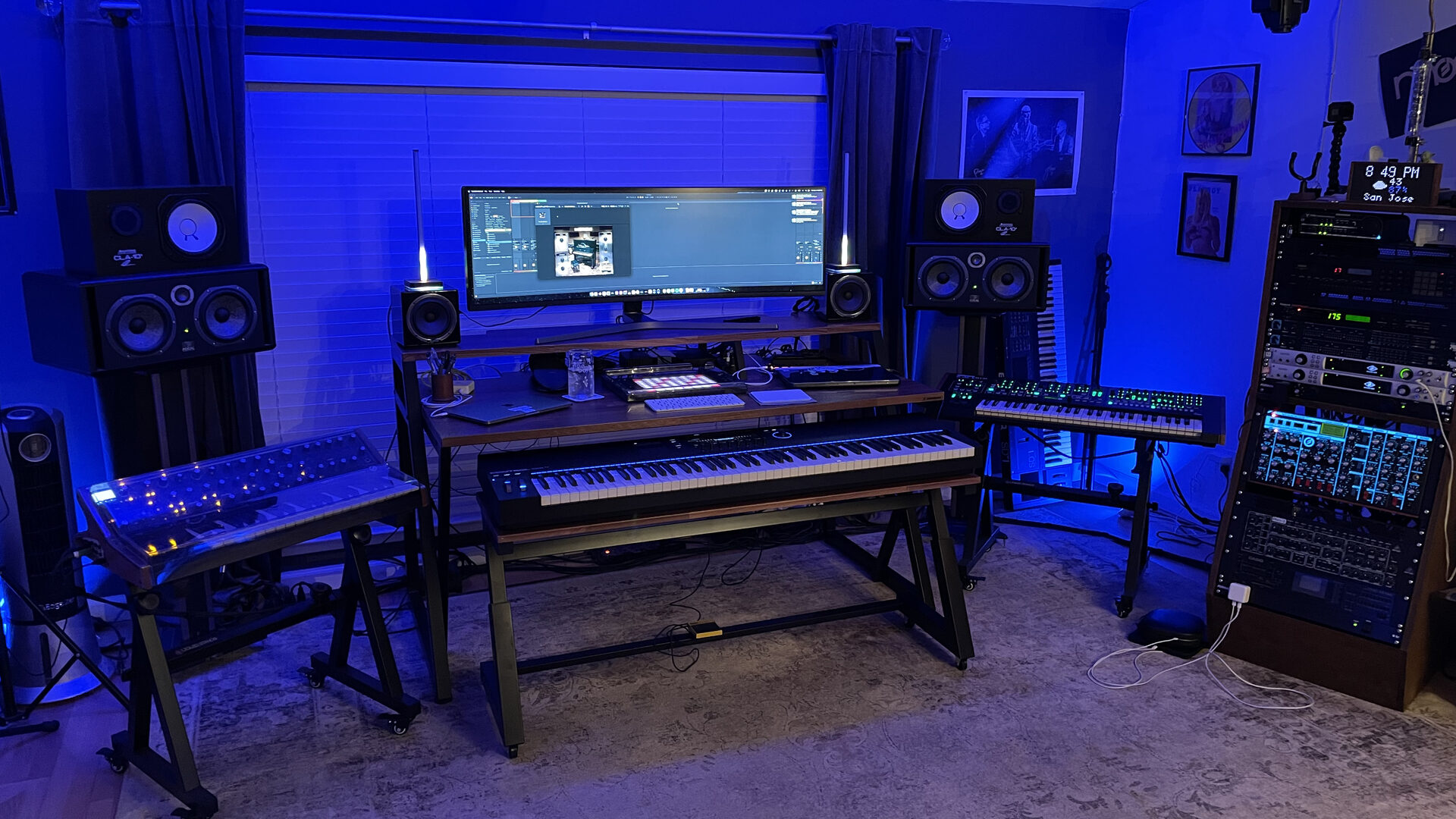 Den Jones’s studio: synths, studio monitors and outboard gear under blue light